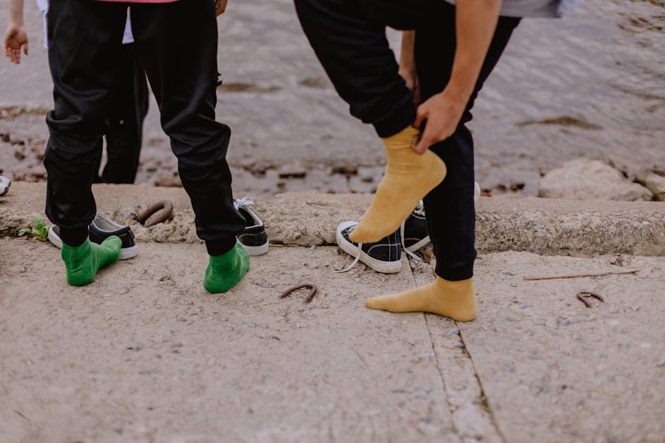 Two people standing by the water, showcasing colorful socks and casual sneakers.