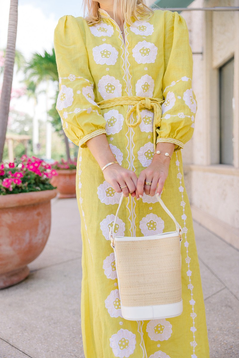 Close view of a woman holding a slim structured Boo rattan tote