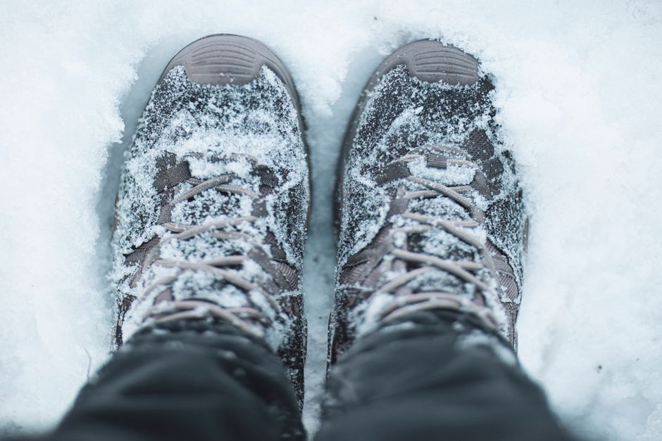 Close-up of snow-covered hiking shoes in a winter scene, capturing the essence of outdoor 