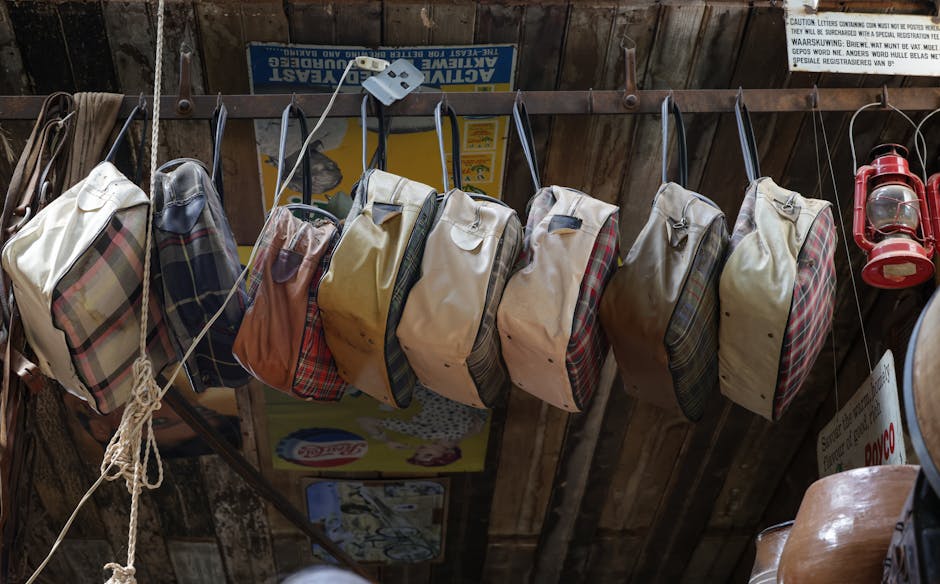 A collection of vintage travel bags hanging in a rustic indoor setting with a retro vibe.