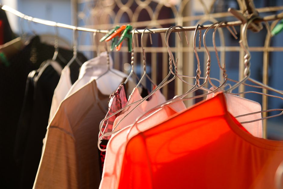 Bright clothes hanging on a line in warm sunlight, casting shadows.