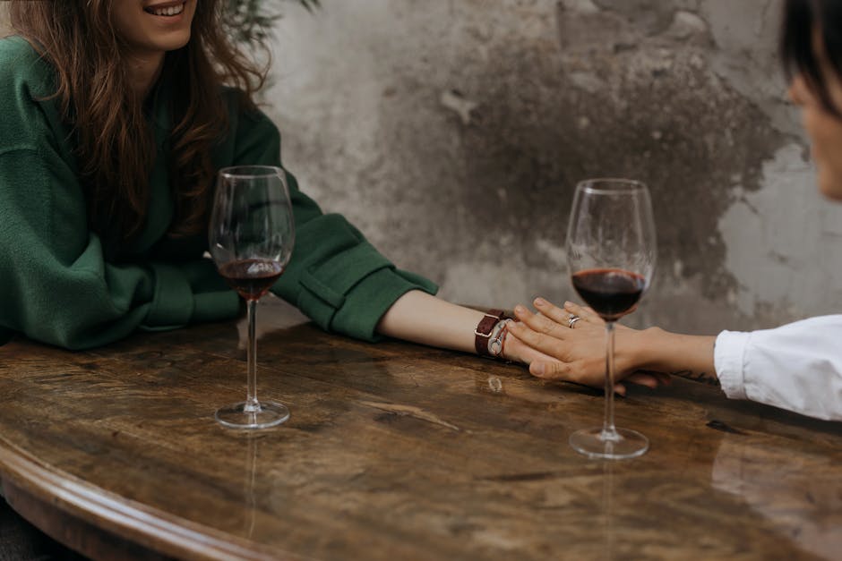 A romantic moment shared over red wine in an intimate indoor setting.