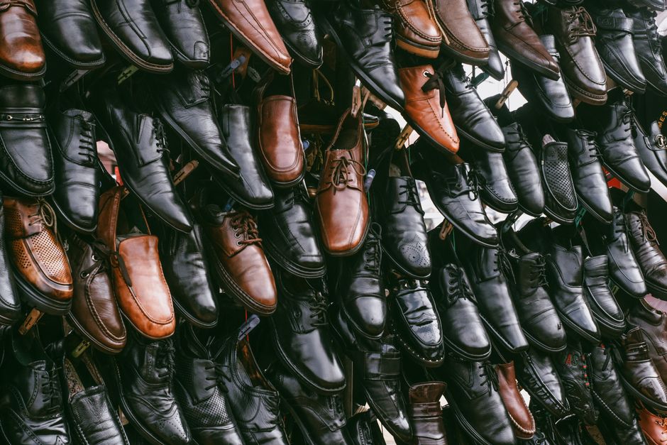 Various leather shoes in black and brown on display, creating a vintage aesthetic.
