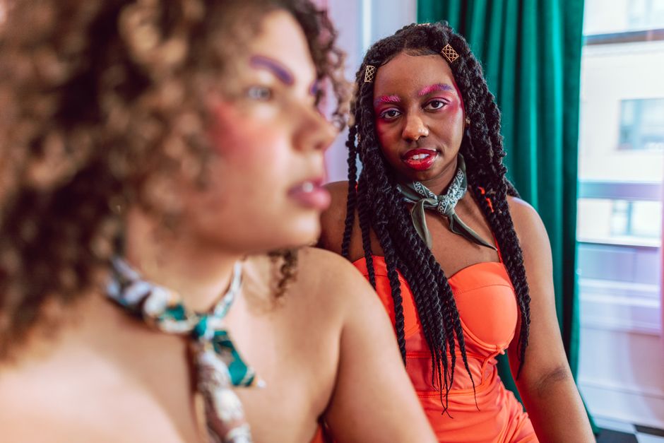 Colorful indoor portrait of two young women with stylish makeup and fashion.