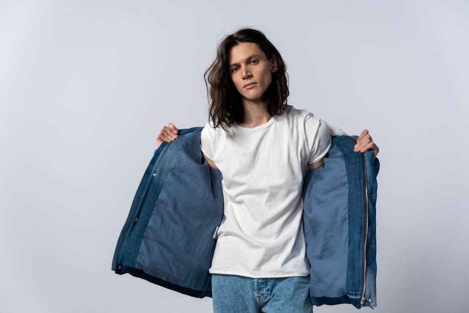 Fashionable model posing in a white shirt and denim, showcasing a modern style.