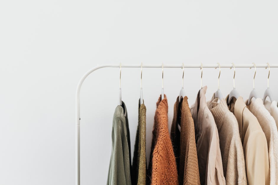 A minimalist clothing rack displaying neutral-toned outfits in an organized indoor setting.