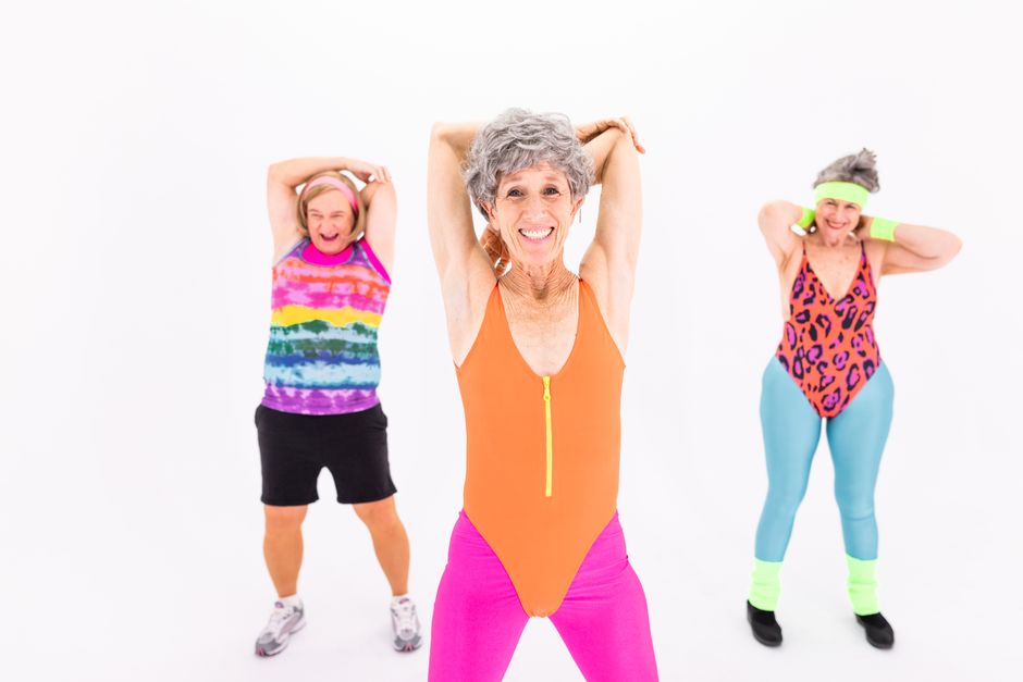 Senior women in vibrant activewear enjoying an aerobic exercise session with enthusiasm and joy.